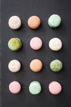 Macarons cake, sweet macaroon on top black food background.の写真素材
