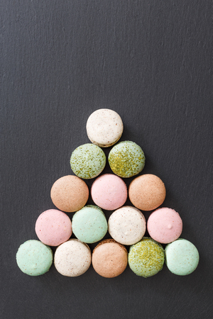 Color cake macarons, sweet macaroon. Creative billiard concept, black slate, natural backgroundの写真素材