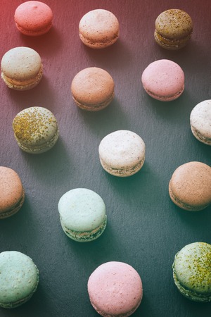 Macarons cake, sweet macaroon on top view flat lay black food background.の写真素材