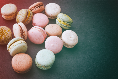 Macarons cake, sweet macaroon on top view flat lay black food background.の写真素材