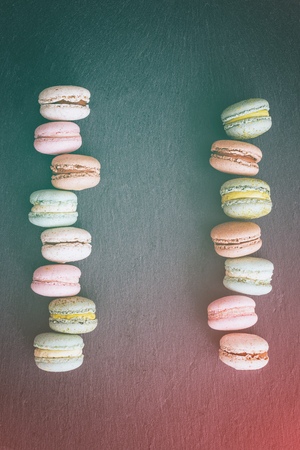 Macarons cake, sweet macaroon on top view flat lay black food background.の写真素材