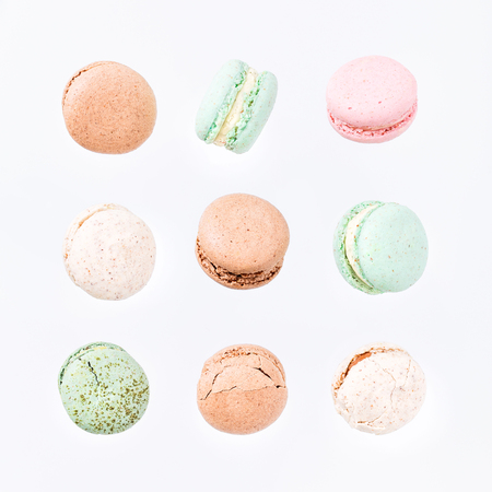 Colorful macarons cake, top view flat lay, fly falling sweet macaroon on color white isolated background. Minimal concepts falling macaroons pattern above, food backgroundの写真素材