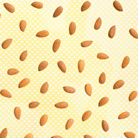 Nuts pattern - almonds on yellow background. Concepts about decoration, healthy eating and food background.の写真素材