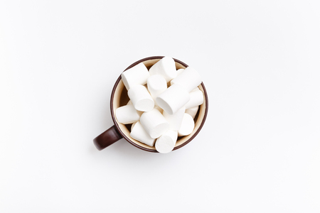 Sweet marshmallow in cup, candy on white background, top view flat lay. Isolated minimal concept above decoration, view white marshmallow, food backgroundの写真素材