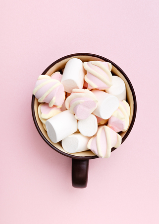 Sweet marshmallow in cup, candy on pink background, top view flat lay. Isolated minimal concept above decoration, view white marshmallow, food backgroundの写真素材