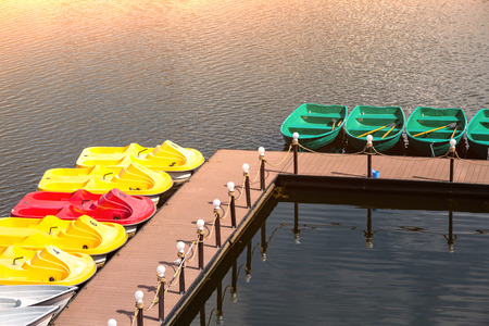 Pier with boats and catamarans for a river walk. City river in downtown. Sunny relax weather.の写真素材