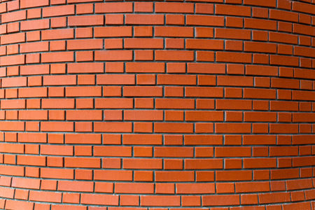 Red brick circle wall background for design. Bricks are bound by cement mortar. Close up view.
