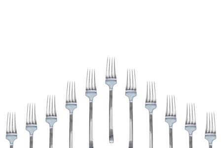 A lot of silver shiny forks. Isolated white background. Concept copy space design.の写真素材
