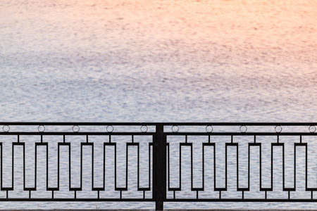 Metal fence (safety railing) on waterfront. Walk along the sea. Copy spaceの写真素材