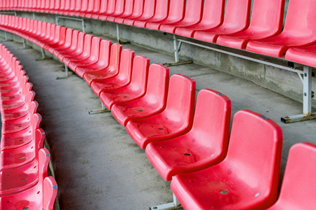 Red stadium seats after rain. Soccer, football or baseball stadium tribune without fans. End of the game.の写真素材