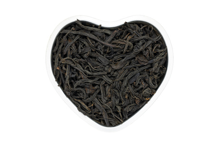 Lapsang souchong tea, heart-shaped, isolated, close up. Smoked Chinese Black Tea use for weight...