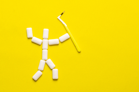Braces cleaning concept with copy space. Chewing gums pads in the shape of a little man with brush for cleaning braces. Protect teeth enamel from tooth decay or plaque concept. Oral hygiene.の写真素材