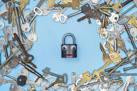 Keys set with funny lock in middle concept, blue background. Choosing of door lock keys and safes for property security and house protection. Different antique and new types of keys.の写真素材