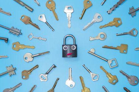 Keys set with funny lock concept, blue background. Choosing the best security system for home and business. Door lock keys and safes for property security and house protection.の写真素材