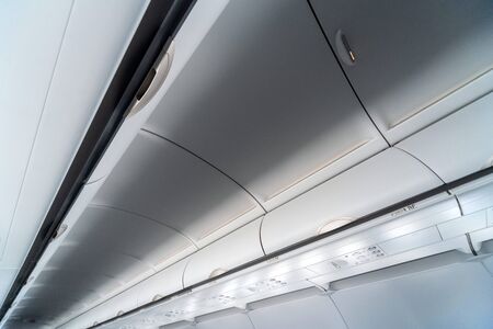 Airplane air conditioning control panel over seats. Stuffy air in aircraft cabin with people. New...