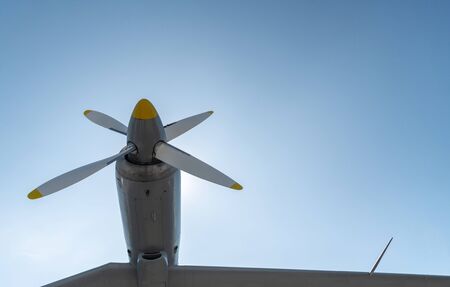 Airplane propeller of military aircraft, copy space. Blue sky sunny background.