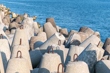 Breakwaters in sea. Beautiful sunset seascape with concrete tetrapodes for protect coastal...