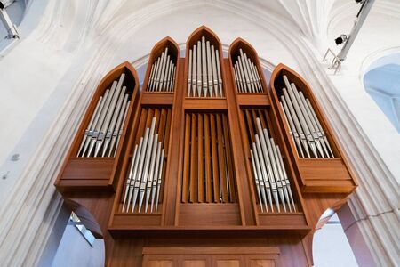 Organ music instrument. Cathedral acoustic sound. Wooden arch and metal pipes.の写真素材