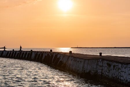 Sea sunset over baltic pier. Dreams of travel and freedom. Beautiful jetty seascape. Sundown sky and claim weather.の写真素材