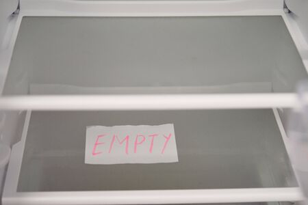 Empty refrigerator concept. Empty shelves of new refrigerator. Weight loss diet concept.