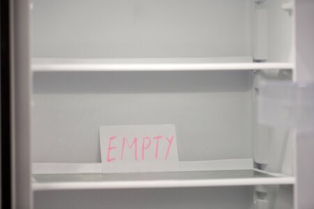 Empty refrigerator concept. Empty shelves of new refrigerator. Weight loss diet concept.の写真素材