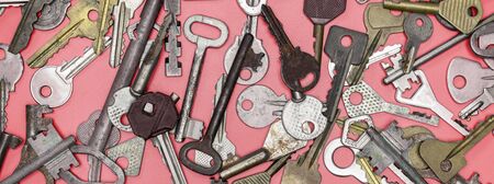 Keys set on pink background. Door lock keys and safes for property security and house protection. Different antique and new types of keys.の写真素材