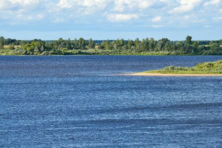 River landscape. Blue deep water with fast current. Green thickets on other coast.