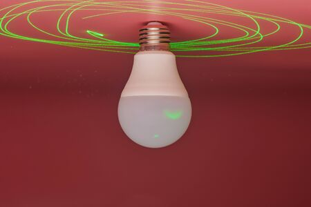 Light bulb and green laser beam around, energy saving. Minimal idea concept.