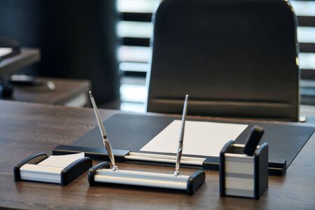 Office workplace with stationery. Boss, chief, supervisor or head of company working place in modern office. Comfortable work table and leather computer chair.の写真素材
