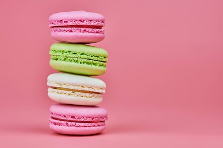 Macaroons on pink background. Colorful small cookie from ground almonds and coconut. Popular...