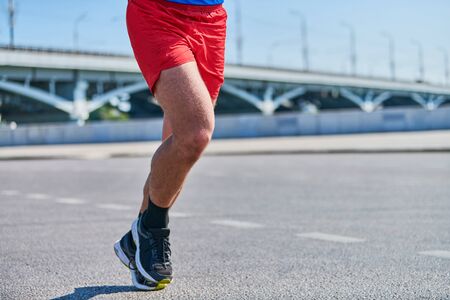 Running man. Athletic man jogging in sportswear on city road. Healthy lifestyle, fitness sport hobby. Street workout, sprinting outdoorの写真素材