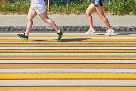 Man running crosswalk, copy space. Athletic man jogging in sportswear on city road. Healthy lifestyle, fitness sport hobby. Traffic violation. Street workout, sprinting outdoorの写真素材