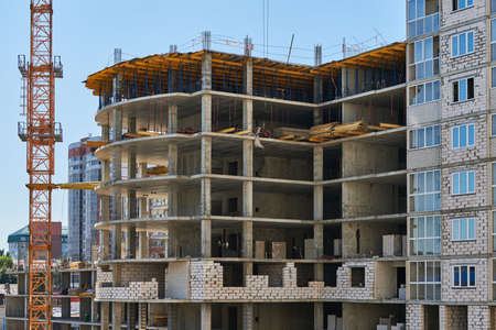 Scaffolding on construction site. Incomplete building and decoration with scaffolds. Work in...