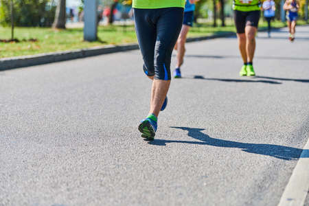 Running man. Athletic man jogging in sportswear on city road. Street marathon race, sprinting...