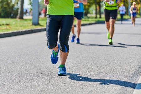 Running man. Athletic man jogging in sportswear on city road. Street marathon race, sprinting outdoor. Healthy lifestyle, fitness sport hobby.の写真素材
