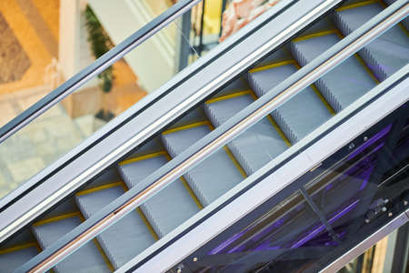 Escalators in shopping center. Empty moving staircase up and down in office building, shopping mall...