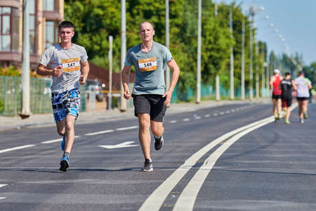 Voronezh, Russia - 08.24.2019 - Marathon runners on city road. Running competition, copy space. Street sprinting outdoors. Healthy sport event.のeditorial素材