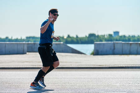 Voronezh, Russia - 08.24.2019 - Young man runs along road. Runners marathon and championship...