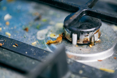 Dirty stove top with oil splatters, fat stains and food leftovers. Unclean steel kitchen cooktop with greasy spots. Spring-cleaning, removing kitchen old stains, fry spots, crumbs and burned-on bitsの写真素材