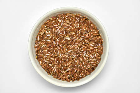 Flaxseed, linseed in bowl, isolated. Bunch of Linum usitatissimum - common flax seeds. Healthy vegetarian nutritional additive for diet.の写真素材