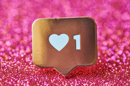 Like heart symbol. Like sign button, symbol with heart and one digit. Social media network marketing. Red glitter sparks background.の写真素材