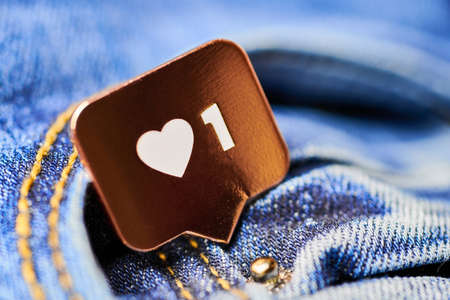Like heart symbol. Like sign button, symbol with heart and one digit. Social media network marketing. Blue jeans texture background.の写真素材