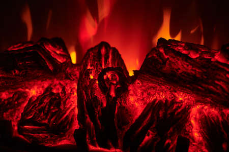 Artificial electric fireplace with orange, red and yellow flame. Fire close up view. Cozy romantic light.の写真素材