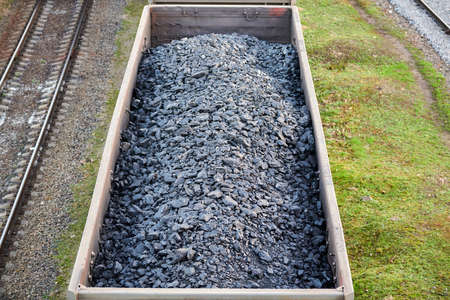 Railway cargo cars loaded with coal. Freight train transporting coal, wood, fuel. Top view.の写真素材