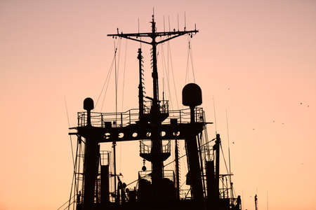 Silhouettes of ships and container cranes in sea port, sunset background. Scenery industrial landscape.の写真素材