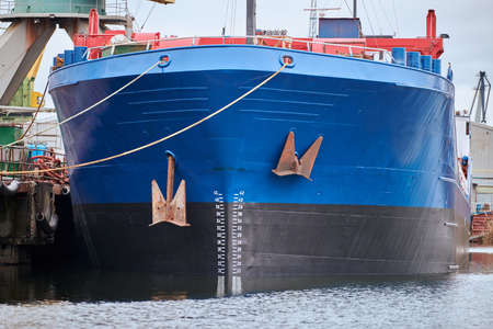 Front view of moored large cargo ship. Freighter in shipyard. Seaport, container ship terminal....