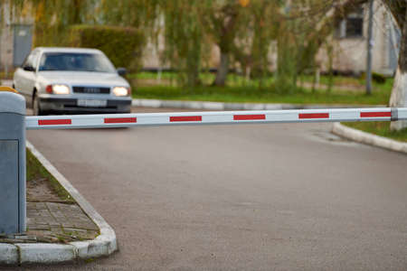 Parking gate, automatic car barrier system for car-park security. White red boom gate.