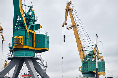 Massive harbor cranes in seaport. Heavy load dockside cranes in port, cargo container yard,...