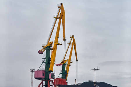 Massive harbor cranes in seaport. Heavy load dockside cranes in port, cargo container yard,...