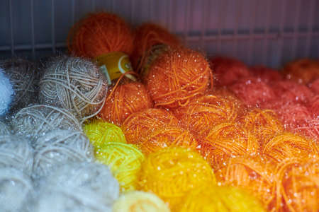 Close up of multicolored yarn balls in knitting shop center. A lot of color yarn for knitting....